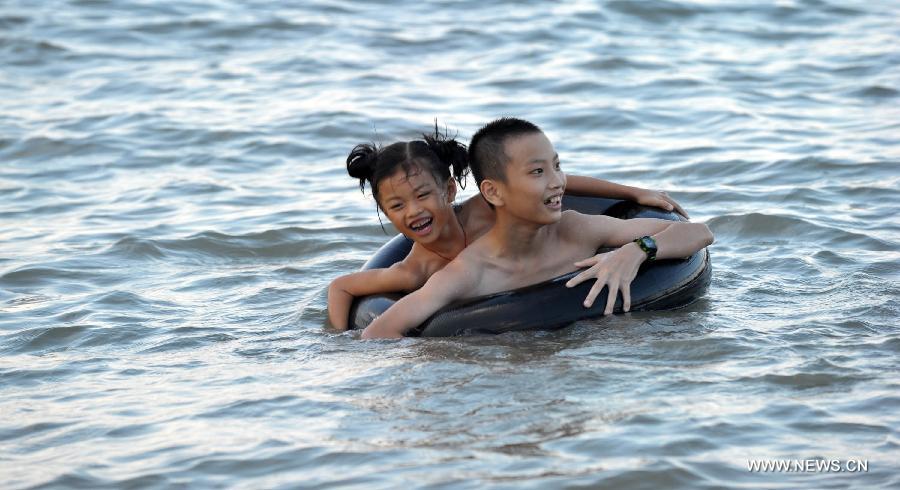 Children play in the sea near Haikou, capital of south China's Hainan Province, June 29, 2013. The highest temperature in Haikou reached 35 degree centigrade, driving local residents to the seashore. (Xinhua/Zhao Yingquan)