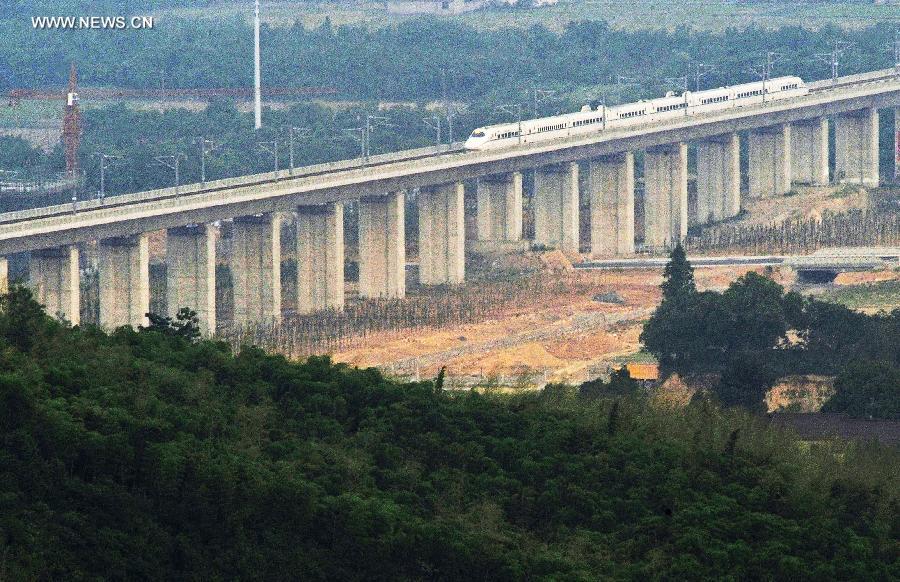 Photo taken on May 24, 2013 shows a bullet train on its trial trip in Huzhou City, east China's Zhejiang Province. A new high-speed railway that stretches across east China's Yangtze River Delta is scheduled to go into commercial service on July 1. The Nanjing-Hangzhou-Ningbo high-speed railway, with a designated top speed of 350 km per hour, will cut travel time between Nanjing, capital of east China's Jiangsu Province, and the port city of Ningbo in east China's Zhejiang Province to about two hours. High-speed trains will run at a speed of 300 km per hour during the initial operation period. (Xinhua/Tan Jin)