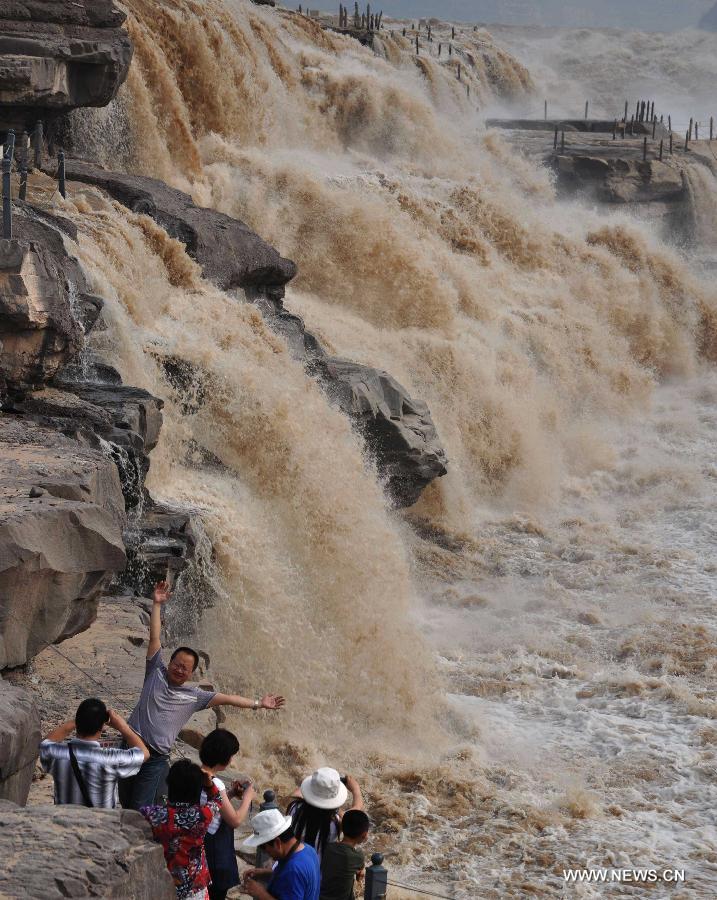 People gather to watch the Hukou Waterfall of the Yellow River in Jixian County, north China's Shanxi Province, June 30, 2013. (Xinhua/Lv Guiming) 
