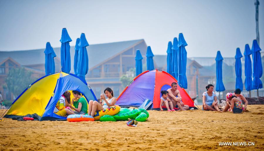 People set up tents to avoid summer heat on the bathing beach in Dongjiangwan of north China's Tianjin Municipality, June 30, 2013. Many people came to Dongjiangwan to spend their weekends. (Xinhua/Zhang Chaoqun)