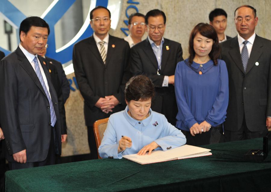 Republic of Korea (ROK) President Park Geun-hye writes down her comments after visiting the ancient terracotta army buried for centuries to guard the tomb of China's first emperor Qinshihuang of the Qin Dynasty (221 BC-207 BC), in Xi'an, capital city of northwest China's Shaanxi Province, on June 30, 2013. (Xinhua/Ding Haitao) 