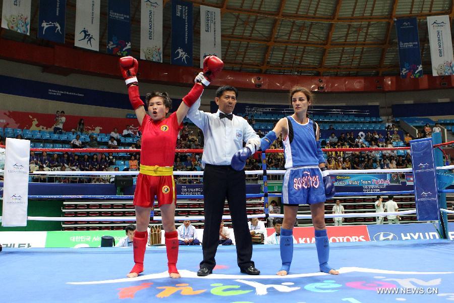 Yuan Xiaoyan (L) of China celebrates after her Muay women's 51kg quarterfinal fight against Aoun Anita of Lebanon during the 4th Asian Indoor and Martial Arts Games (AIMAG) in Incheon, South Korea, June 30, 2013. Yuan Xiaoyan won 5-0. (Xinhua/Park Jin-hee)