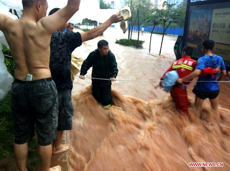 Firefighters establish a warning line in flood in Suining City, southwest China's Sichuan Province, June 30, 2013. Two people died and five others are missing in Sichuan Province after torrential rain triggered flooding and landslides in the region on Sunday, local authorities said. (Xinhua/Hu Ming) 
