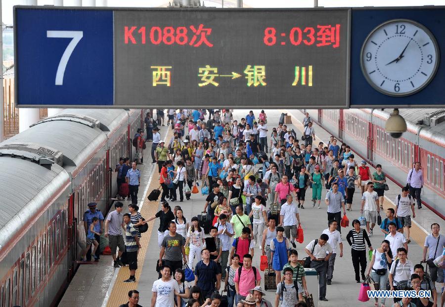 Passengers walk on the platform at the Yinchuan Railway Station in Yinchuan, capital of northwest China's Ningxia Hui Autonomous Region, July 1, 2013. China's summer railway travel rush started on Monday and will last until Aug. 31. (Xinhua/Peng Zhaozhi) 