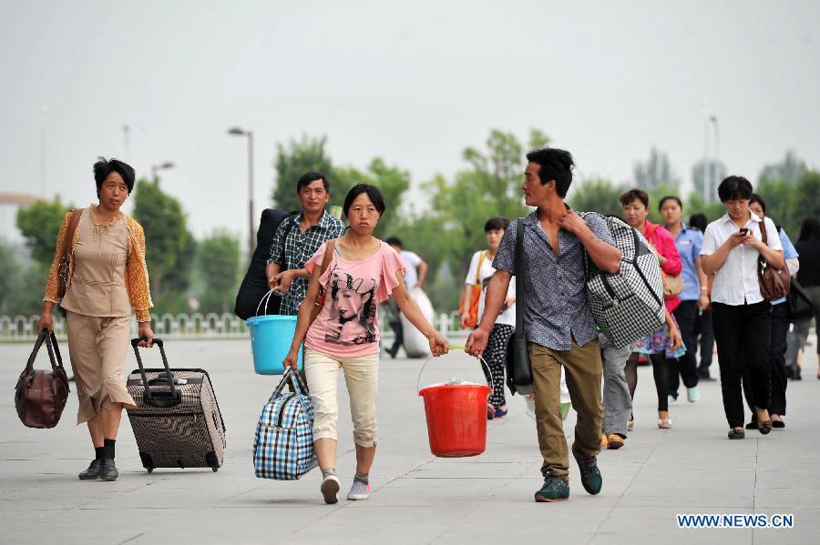 Passenger arrive at the Yinchuan Railway Station in Yinchuan, capital of northwest China's Ningxia Hui Autonomous Region, July 1, 2013. China's summer railway travel rush started on Monday and will last until Aug. 31. (Xinhua/Peng Zhaozhi) 