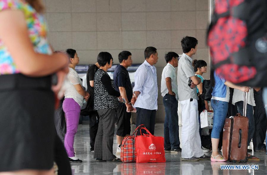 Passengers queue to buy tickets at the Yinchuan Railway Station in Yinchuan, capital of northwest China's Ningxia Hui Autonomous Region, July 1, 2013. China's summer railway travel rush started on Monday and will last until Aug. 31. (Xinhua/Peng Zhaozhi)