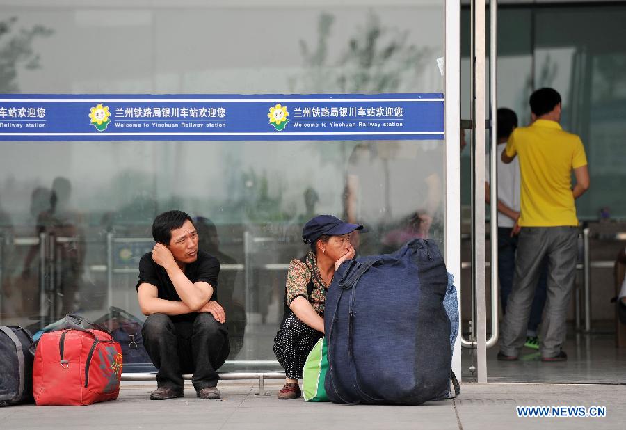 Passengers rest outside the ticket office at the Yinchuan Railway Station in Yinchuan, capital of northwest China's Ningxia Hui Autonomous Region, July 1, 2013. China's summer railway travel rush started on Monday and will last until Aug. 31. (Xinhua/Peng Zhaozhi) 