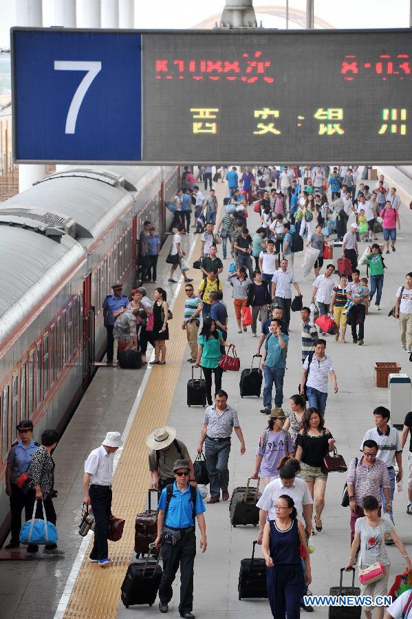 Passengers walk on the platform at the Yinchuan Railway Station in Yinchuan, capital of northwest China's Ningxia Hui Autonomous Region, July 1, 2013. China's summer railway travel rush started on Monday and will last until Aug. 31. (Xinhua/Peng Zhaozhi) 