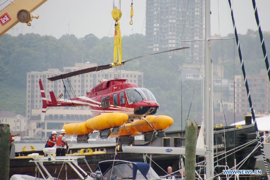 A helicopter is seen lifted from the Hudson River by a crane off Manhattan, New York, the United States, June 30, 2013. The helicopter carrying four tourists made an emergency landing on Saturday in the Hudson River with no casualty. (Xinhua/David Torres)