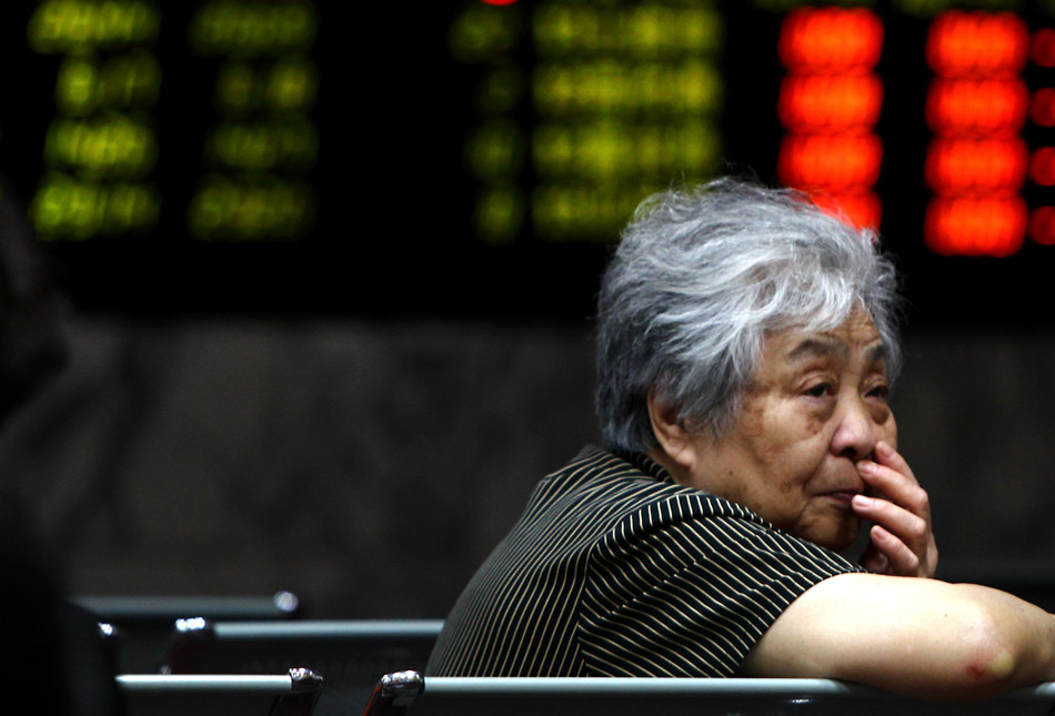 An investor is seen in a trading hall of a securities firm in Shanghai, June 24, 2013. Chinese shares plunged on Monday and closed below a key psychological mark over worries about the liquidity crunch in the financial system and subdued strength in the world's second largest economy. The benchmark Shanghai Composite Index tumbled 5.3 percent to end at 1,963.24, the lowest point in nearly seven months, while the Shenzhen Component Index plummeted 6.73 percent to 7,588.52. (Xinhua/Pei Xin)
