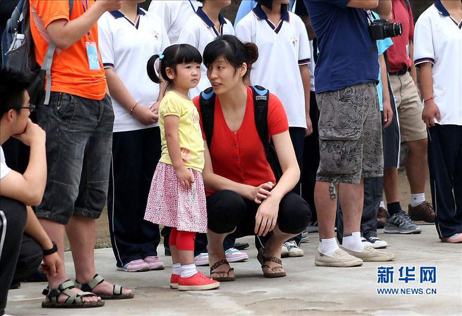 Yao Ming's three-year-old daughter and wife. Former NBA star Yao Ming and his family pay a visit to a primary school for children from migrant workers' families in Changping district in the northern suburbs of Beijing, Sunday, June 30, 2013. The visit is part of the Yao Foundation charity events in 2013, which inlcude a charity basketball game on July 1, 2013 in MasterCard Center in Beijing. 