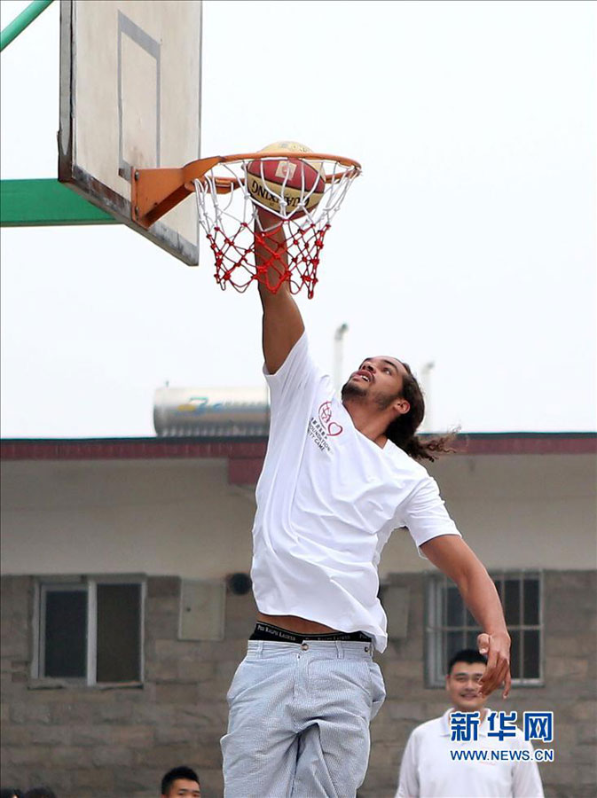 Joakim Noah of Chicago Bulls shows off his skills during his visit to a primary school for children from migrant workers' families in Changping district in the northern suburbs of Beijing Sunday, June 30, 2013.