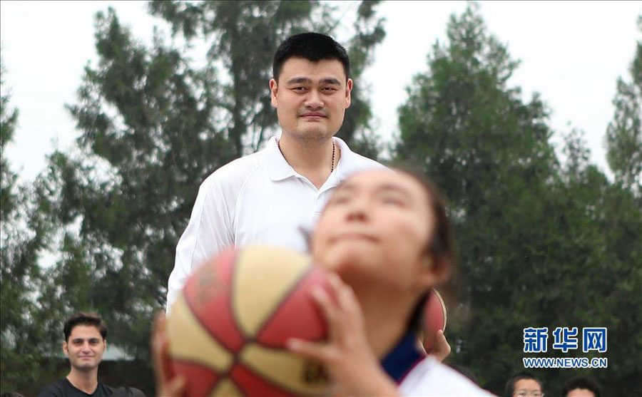 Former NBA star Yao Ming and his family pay a visit to a primary school for children from migrant workers' families in Changping district in the northern suburbs of Beijing, Sunday, June 30, 2013. The visit is part of the Yao Foundation charity events in 2013, which inlcude a charity basketball game on July 1, 2013 in MasterCard Center in Beijing. 