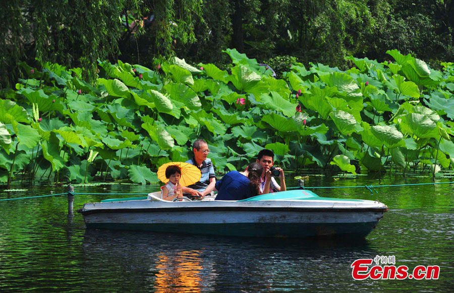 Visitors take photos for lotus flowers in Guyi Garden in Nanxiang Town, Jiading District, Shanghai, June 30, 2013. Originally called "Yi Garden," where "Yi" means a beautiful view of bamboo, Guyi Garden was designed by a well-known bamboo-carving master from the Ming Dynasty. (CNS/Yuan Jing)