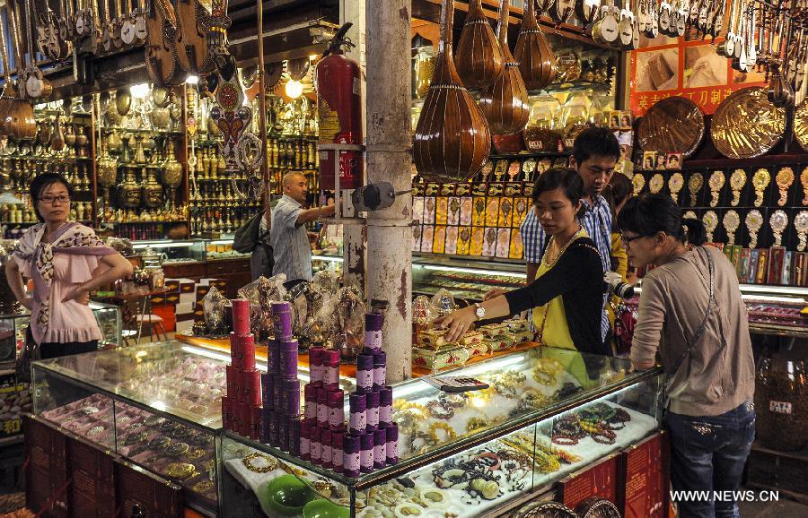 Tourists select handicrafts at Kashi Grand Bazzar in Kashi Prefecture, northwest China's Xinjiang Uygur Autonomous Region, June 30, 2013. Kashi Grand Bazzar is the largest international business market in China's northwest region. Bazzar in Uygur language means market or fair. (Xinhua/Shen Qiao)