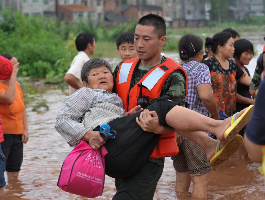 A fireman helps evacuate an elderly woman at Baizi Town in Tongnan County of Chongqing, southwest China's municipality, July 1, 2013. Rainstorms swept the county Sunday, flooding low-lying area and forcing the evacuation of some 18,000 people. (Xinhua/Liu Chan) 