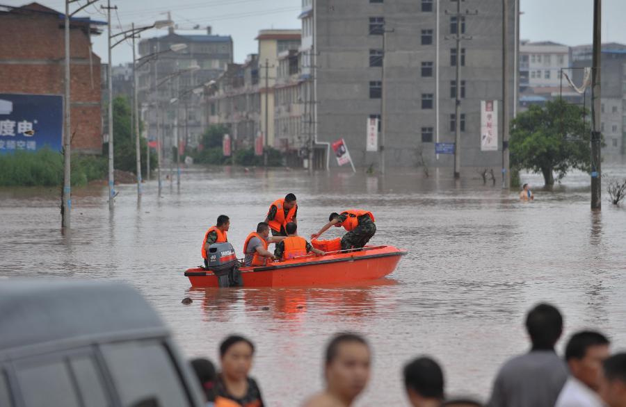 Firemen drive a boat to help evacuate residents at Baizi Town in Tongnan County of Chongqing, southwest China's municipality, July 1, 2013. Rainstorms swept the county Sunday, flooding low-lying area and forcing the evacuation of some 18,000 people. (Xinhua/Liu Chan) 