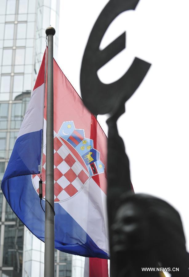 A Croatian flag is seen in front of the European Parliament building in Brussels, capital of Belgium, July 1, 2013. Croatia became the 28th member of the European Union on Monday. (Xinhua/Ye Pingfan)