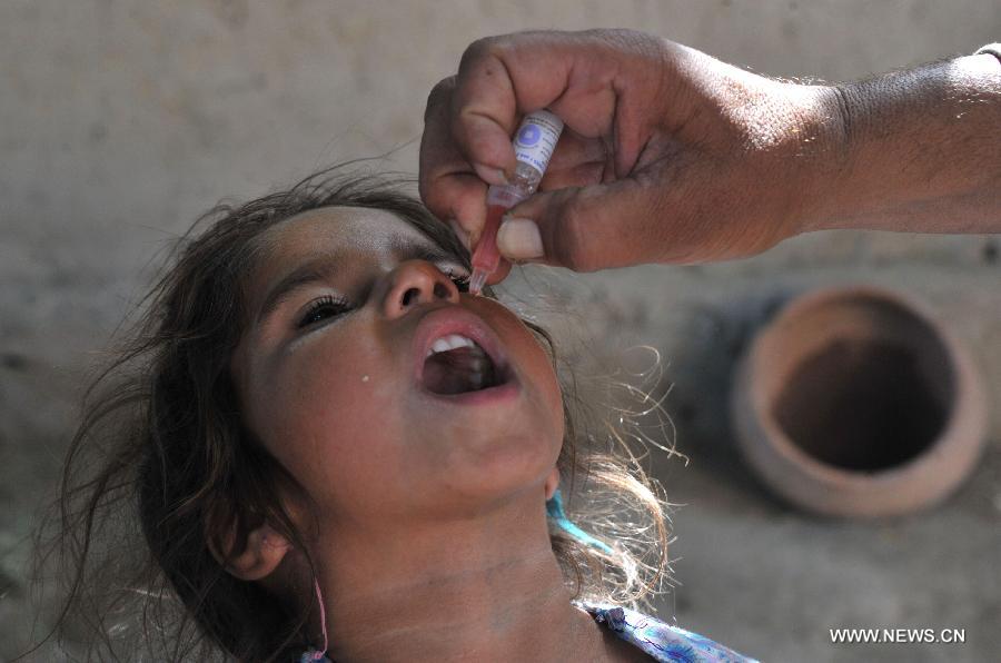 A girl receives polio vaccine from an Afghan health worker in east Afghanistan's Nangarhar Province, July 1, 2013. Afghanistan launched a three-day nationwide polio vaccination in order to immunize children under five against polio. (Xinhua/Tahir Safi)