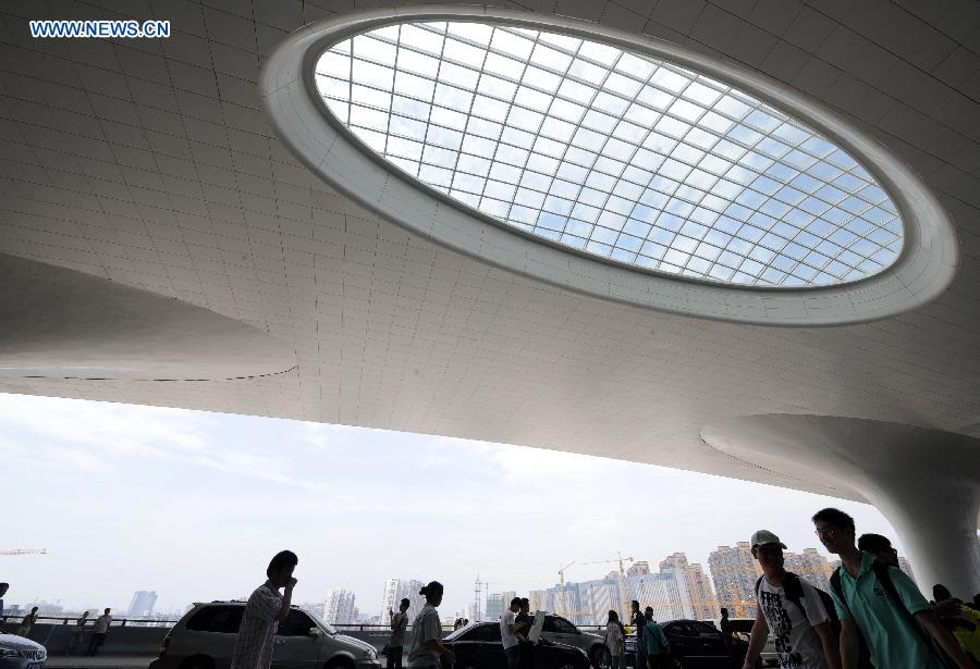 Passengers are seen at the newly-opened Hangzhou East Station in Hangzhou, capital of east China's Zhejiang Province, July 1, 2013. With the building area of 1.13 million square meters, the Hangzhou East Station, China's largest railway terminal, officially opened on Monday. (Xinhua/Sun Can)