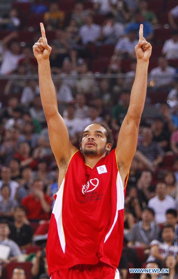 NBA star Joakim Noah celebrates after scoring during a Yao Foundation Charity Game, sponsored by the charity foundation initiated by former Chinese basketball star Yao Ming, between the Chinese team and a team of NBA stars in Beijing, China, July 1, 2013. Team of NBA stars won 61-58. (Xinhua/Ding Xu)