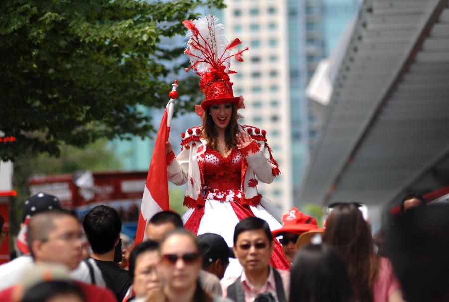 A performer dressed in Canadian colors entertains the public during the Canada Day celebrations in Vancouver, Canada, on July 1, 2013. Tens of thousands of spectators flooded the streets of Vancouver to participate in Canada Day festivities. (Xinhua/Sergei Bachlakov) 