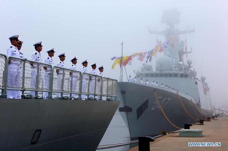 Officers and soldiers of Chinese navy take part in a ceremony for the departure of a fleet in the port of Qingdao, east China's Shandong Province, July 1, 2013. A Chinese fleet consisting of seven naval vessels departed from east China's harbor city of Qingdao on Monday to participate in Sino-Russian joint naval drills scheduled for July 5 to 12. The eight-day maneuvers will focus on joint maritime air defense, joint escorts and marine search and rescue operations. (Xinhua/Zha Chunming)