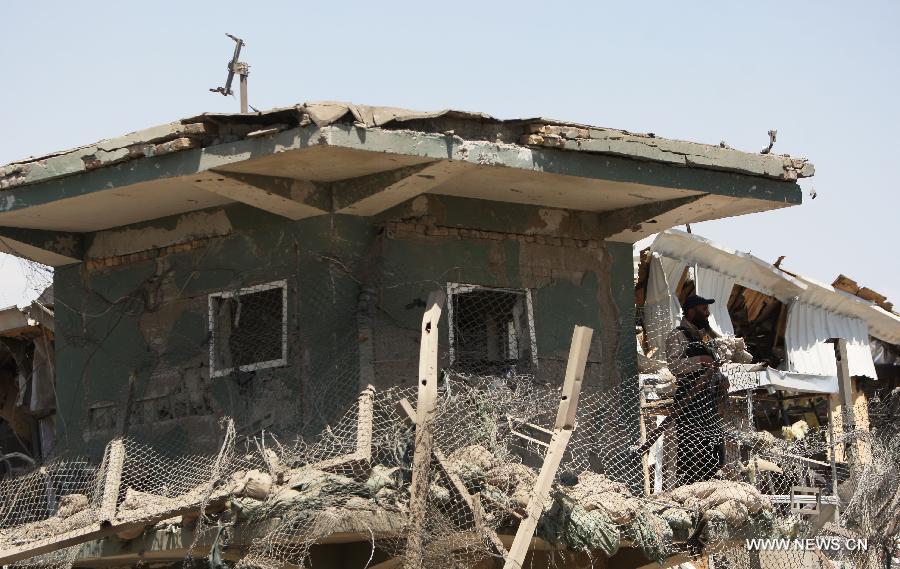 An Afghan soldier stands guard on destroyed control tower at the site of attack in Kabul, Afghanistan, on July 2, 2013. Twelve people including, five Taliban suicide bombers, four Nepalese contractor guards, one Afghan guard and two civilians, were killed in the attack, officials said. (Xinhua/Ahmad Massoud)