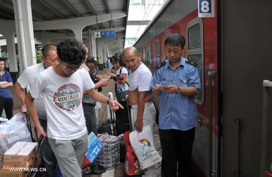 A staff member watches the first direct train from Haikou to Harbin leaving the Haikou Railway Station in Haikou, capital of south China's Hainan Province, July 2, 2013. The train K1122/3 from south China's Haikou to northeast China's Heilongjiang left Haikou Tuesday, a day later than its original departure date due to the tropical storm Rumbia. The train which travels 4,458 kilometers for 65 hours has connected China's southernmost capital city Haikou of Hainan Province with China's northernmost capital city Harbin of Heilongjiang Province. (Xinhua/Zhao Yingquan)