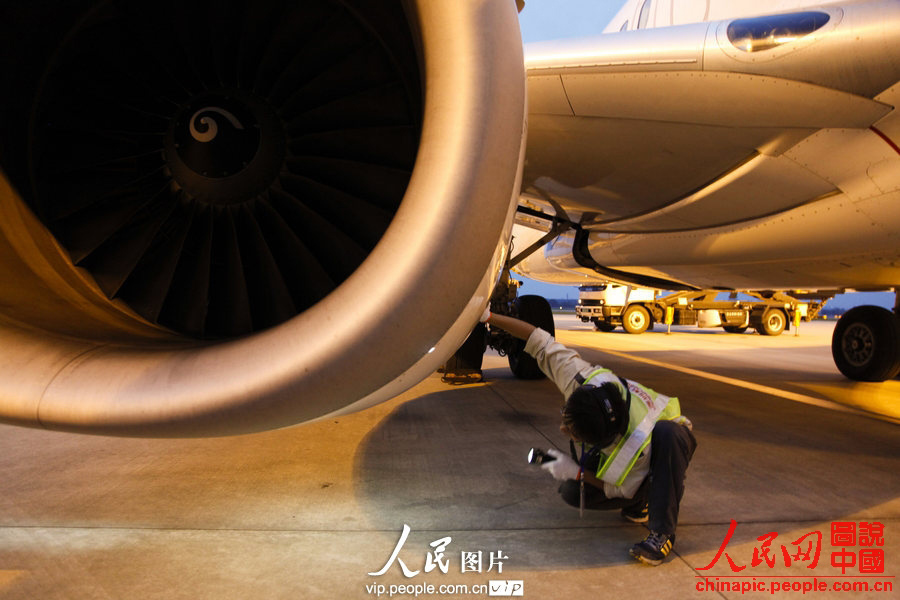 Wang Jin checks the engine. (Photo:Wang Yu/vip.people.com.cn)