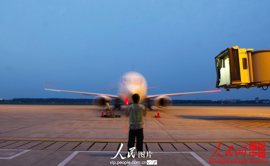 Wang Jin directs a plane to park on the tarmac. (Photo:Wang Yu/vip.people.com.cn)