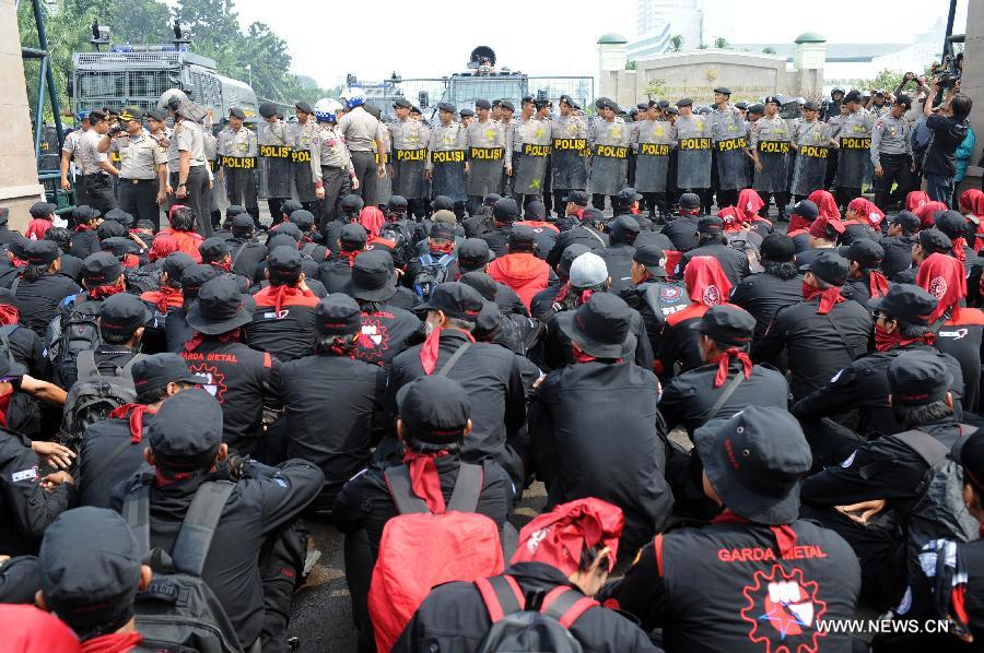 Protesters sit in front of the parlimentary house to refuse mass organization bill which will become law in Jakarta, capital of Indonesia, on July 2, 2013. Workers believe the mass organization bill will suppress freedom of association for all citizens.(Xinhua/Veri Sanovri)