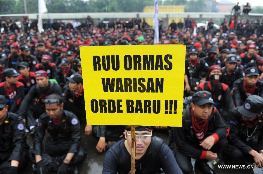 Protesters rally in front of the parlimentary house to refuse mass organization bill which will become law in Jakarta, capital of Indonesia, on July 2, 2013. Workers believe the mass organization bill will suppress freedom of association for all citizens.(Xinhua/Veri Sanovri)