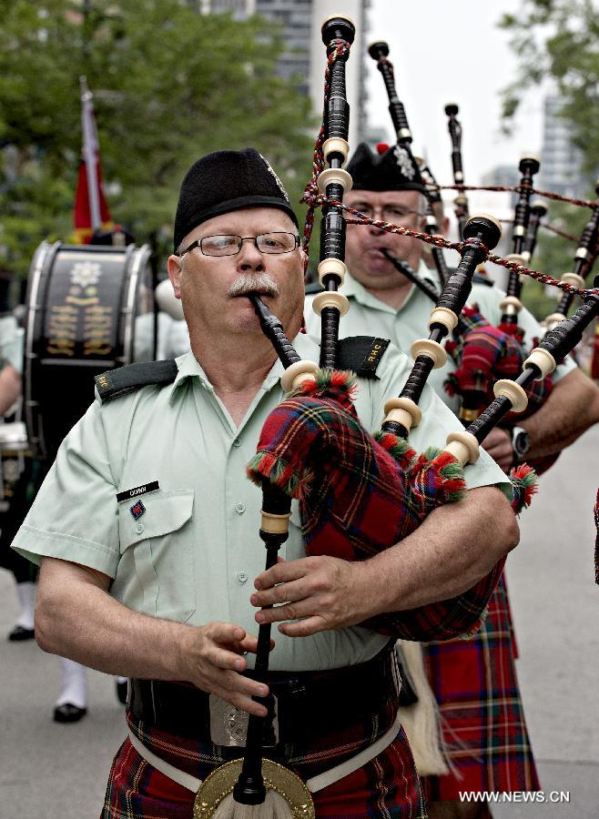 People playing bagpipes attend a parade as a part of Canada Day celebrations in Montreal, Canada, on July 1, 2013. Celebrations were held across the country to mark the 146th anniversary of Canada's foundation. (Xinhua/Andrew Soong) 