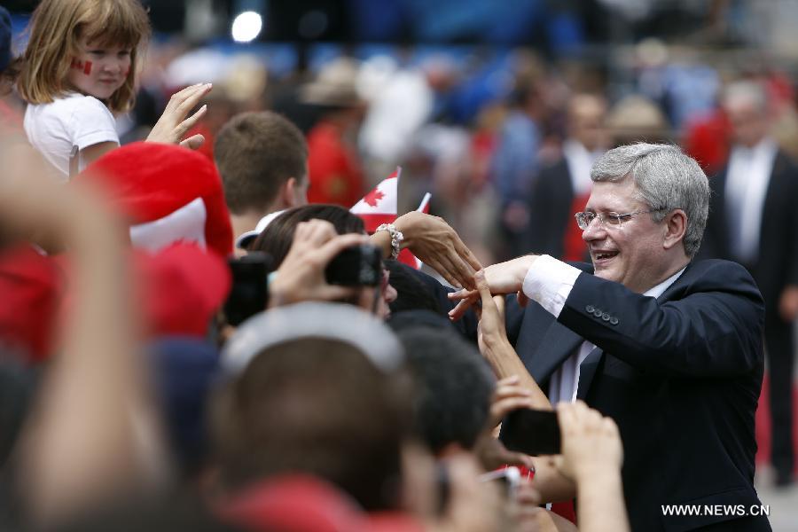 Canada's Prime Minister Stephen Harper (R) greets the crowd after the annual free concert, a part of Canada Day celebrations, in front of Parliament Hill in Ottawa, capital of Canada, on July 1, 2013. Celebrations were held across the country to mark the 146th anniversary of Canada's foundation. (Xinhua/David Kawai) 