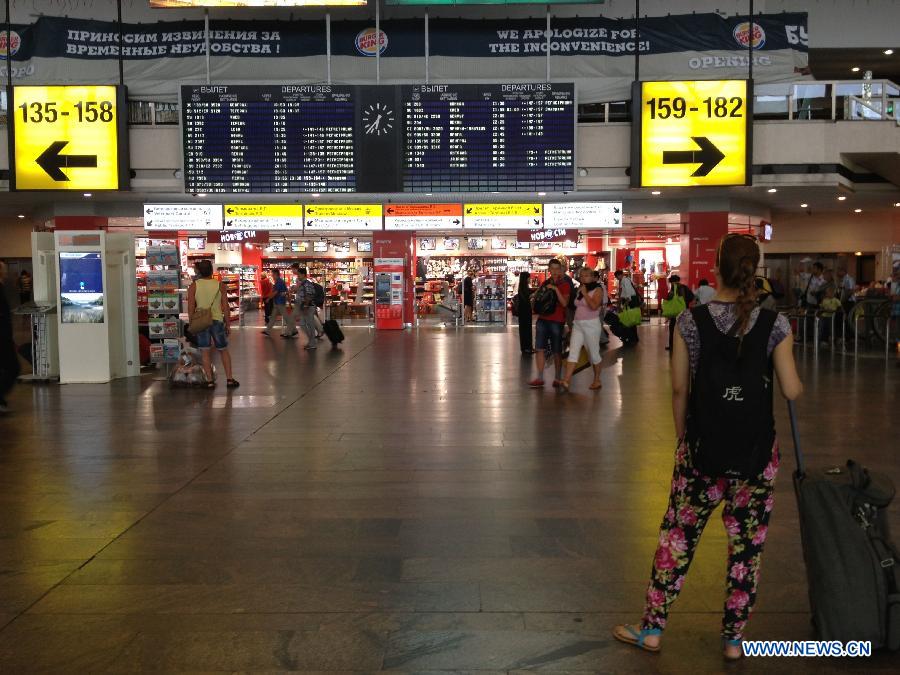 Passengers check flight information at the Sheremetyevo airport in Moscow, Russia, July 2, 2013. Former U.S. intelligence contractor Edward Snowden aborted his intention to ask for political asylum in Russia, Kremlin said Tuesday. (Xinhua/Ding Yuan) 