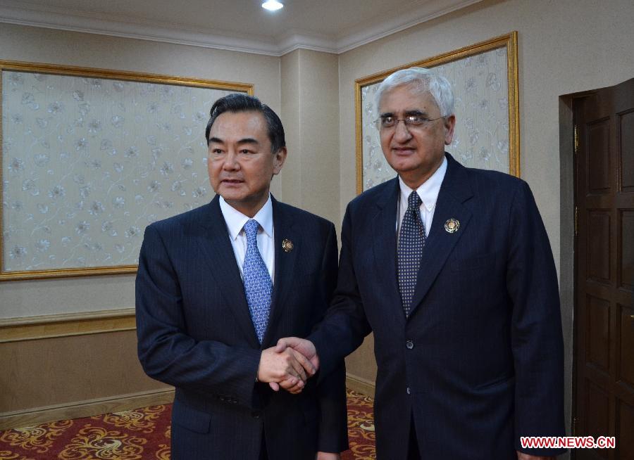 Chinese Foreign Minister Wang Yi (L) shakes hands with Indian Foreign Minister Salman Khurshid in Bandar Seri Begawan, capital of Brunei, on July 2, 2013. (Xinhua/Wu Junlin)