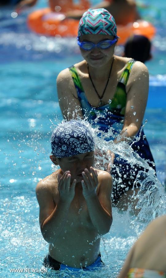 Citizens enjoy coolness at a natatorium in Shijiazhuang, capital of north China's Hebei Province, July 3, 2013. The highest temperatures in many parts of Hebei reached 37 degrees celsius on Wednesday. (Xinhua/Wang Xiao)