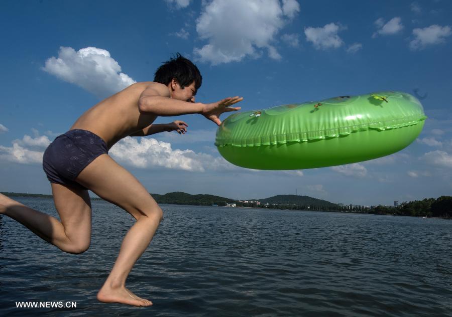 A man jumps into the water at the East Lake in Wuhan, capital of central China's Hubei Province, July 3, 2013. The highest temperature in Wuhan reached 36 degrees celsius on Wednesday. (Xinhua/Cheng Min)