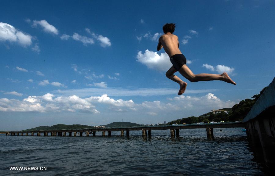 A man jumps into the water at the East Lake in Wuhan, capital of central China's Hubei Province, July 3, 2013. The highest temperature in Wuhan reached 36 degrees celsius on Wednesday. (Xinhua/Cheng Min)
