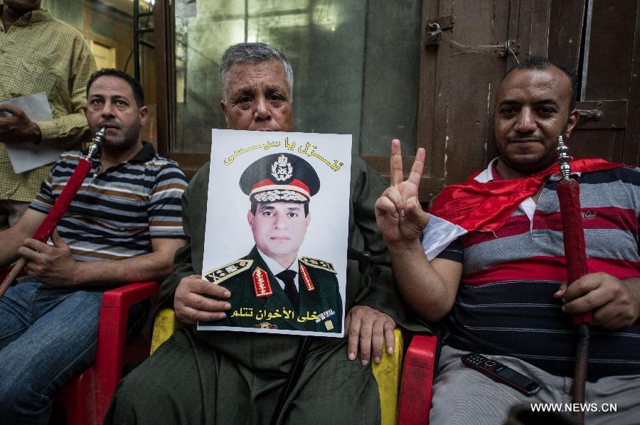 A man holds a picture of Egyptian Defence Minister Abdel Fatah al-Sissi near Cairo's Tahrir Square, Egypt, on July 3, 2013. Egypt's President Mohamed Morsi said Wednesday he would commit to his own roadmap of building a coalition government and setting up a panel for amending the constitution, warning against any other scenarios. (Xinhua/Li Muzi)