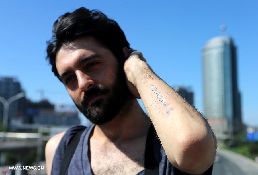 Juan Gonzalez Zamora shows his tattoo reading "The sky is blue" on his arm in Beijing, capital of China, July 2, 2013.  (Xinhua/Zhang Chuanqi) 