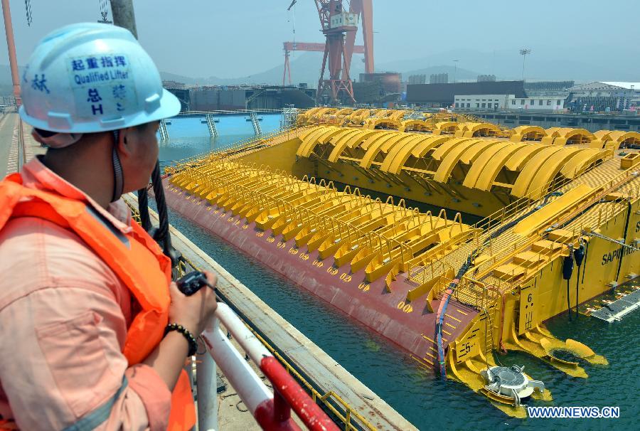 A worker checks a buoy of the newly-built deep-sea engineering equipment in Qingdao, east China's Shandong Province, July 3, 2013. (Xinhua/Wan Houde)