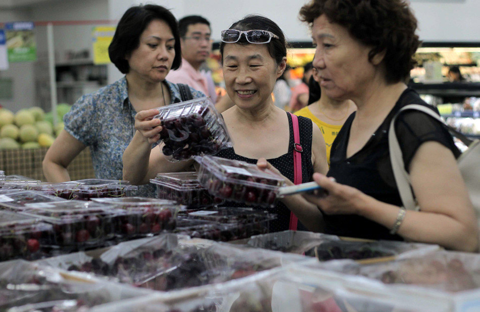 Customers purchase US cherries at a Sam's Club in Beijing. As cherries become increasingly popular in China, so have imports of US cherries, which were worth $75 million in 2012. [Photo / China Daily] 