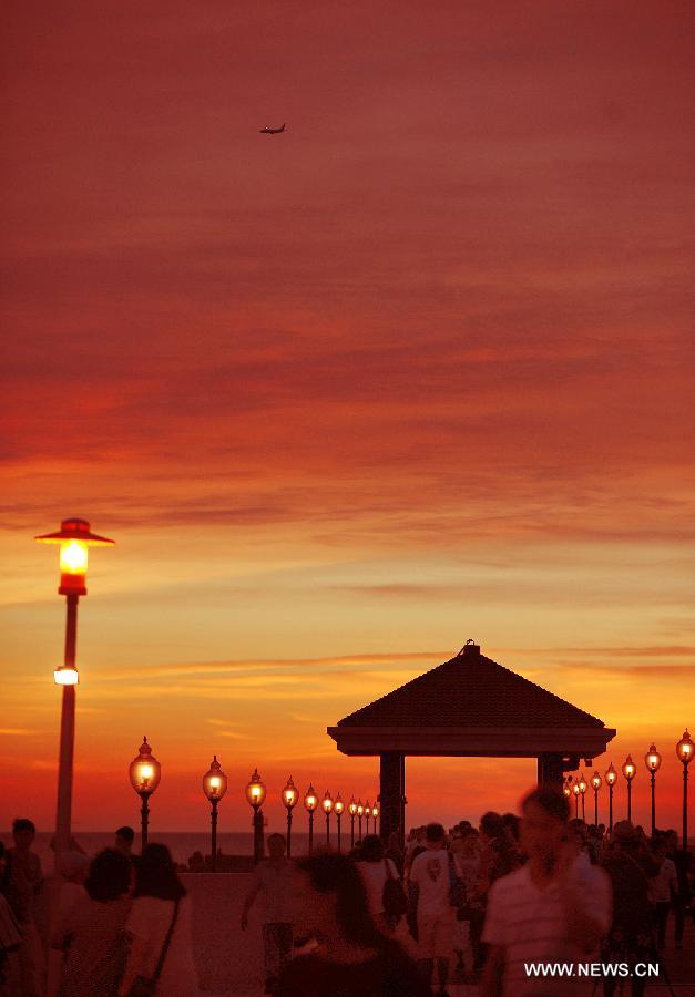 Tourists enjoy the sunset at the "fisherman's wharf" in Danshui, Xinbei, southeast China's Taiwan, July 3, 2013. Dubbed as the "Oriental Venice", Danshui is a pop scenery spot for tourists. (Xinhua/Tao Ming)