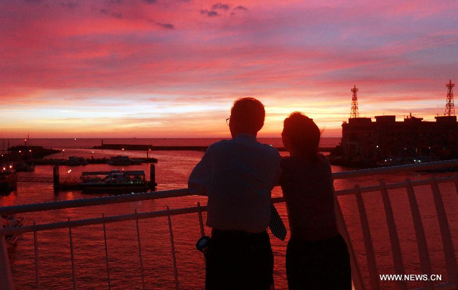 People enjoy the scenery of sunset at the "fisherman's wharf" in Danshui, Xinbei, southeast China's Taiwan, July 3, 2013. Dubbed as the "Oriental Venice", Danshui is a pop scenery spot for tourists. (Xinhua/Tao Ming) 