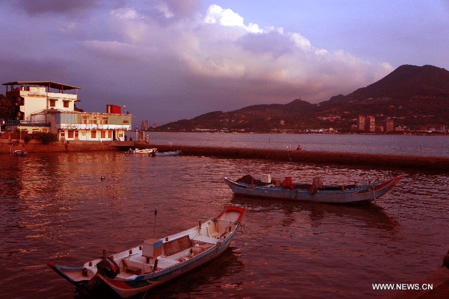 Photo taken on July 3, 2013 shows the scenery of sunset at the "fisherman's wharf" in Danshui, Xinbei, southeast China's Taiwan. Dubbed as the "Oriental Venice", Danshui is a pop scenery spot for tourists. (Xinhua/Tao Ming) 
