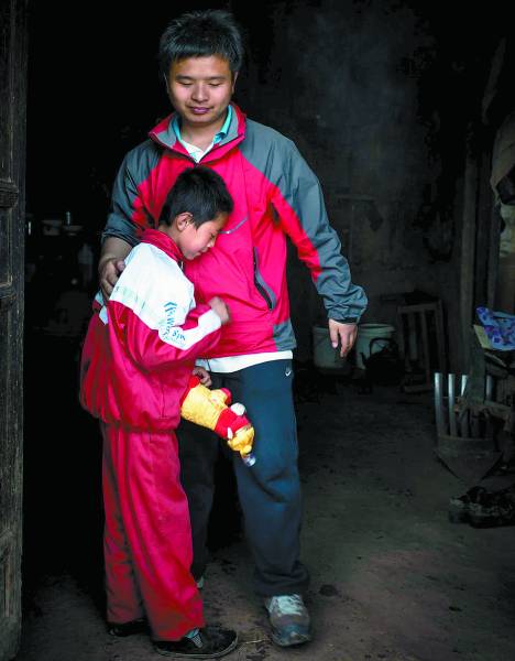 Gu, one of the five student teachers, bids farewell to Ma Funing, a second year student. Holding the toy brought by Gu, Ma felt hard to part from his teacher. (Photo/China Youth Daily)