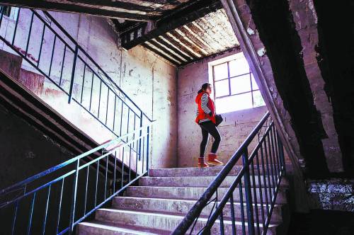 A student teacher walks on the stairs of the dormitory. The room was roughly finished. (Photo/China Youth Daily)