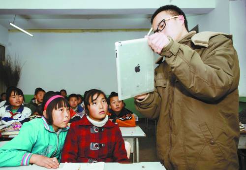 Ma shows an iPad to his students in class. (Photo/China Youth Daily)